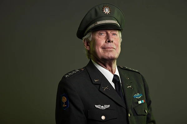 Smiling soldier in US military uniform using laptop